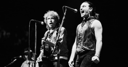 10 de Maio - 1960 - Bono, cantor da banda U2 com Bob Dylan cantando 'Blowing in the Wind'.